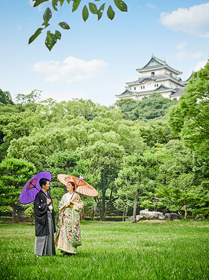 和歌山城をバックに和装で記念写真撮影する新郎新婦のイメージ